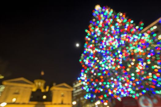 Christmas Holiday Tree with Moon at Pioneer Courthouse Square in Portland Oregon Downtown with Blur Defocused Bokeh Colorful Lights at Night