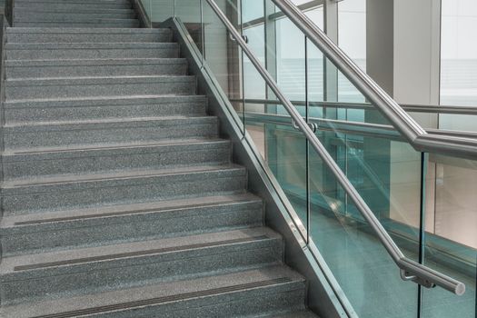 Pattern of several steps of granite stairs with glass railing