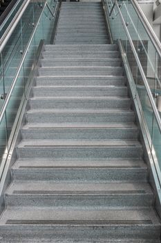 Pattern of several steps of granite stairs with glass railing