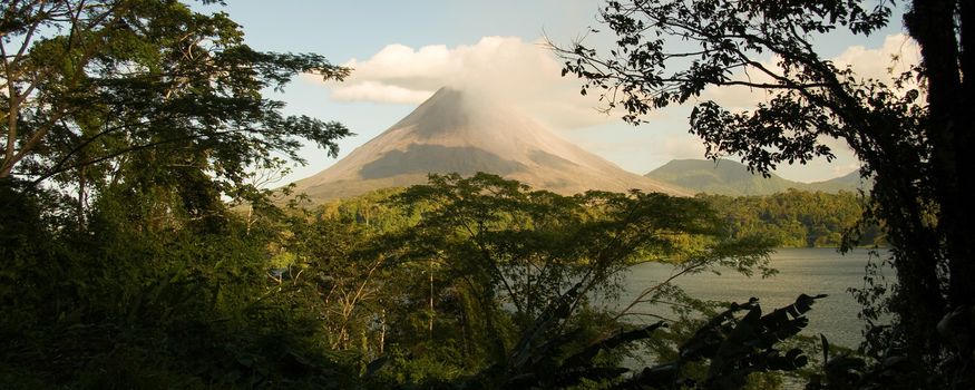 Arenal Volcano through the trees and over Lake Arenal, Costa Rica.