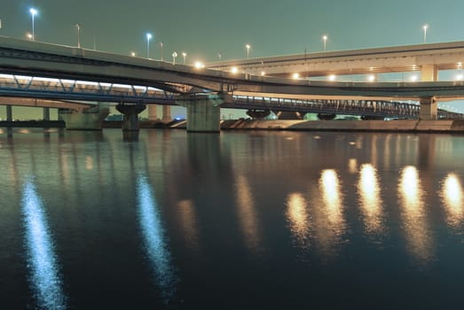 hanged up highways over river waters by night in Tokyo