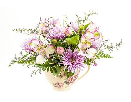 Bouquet of colorful flowers arranged in small vase isolated on white background