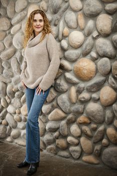 Smiling woman standing in front of stone wall bull body