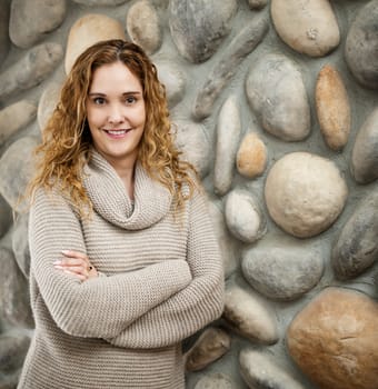 Smiling woman standing in front of stone wall