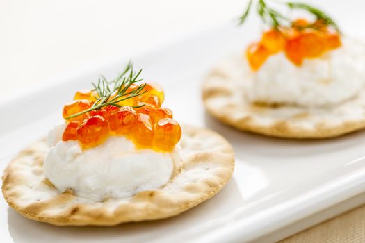 Closeup of caviar and cream cheese appetizer on crackers