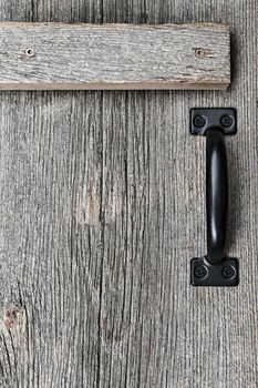 Distressed rustic barn wood door with handle as textured background