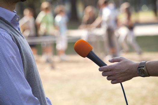 A journalist is making a interview with a microphone