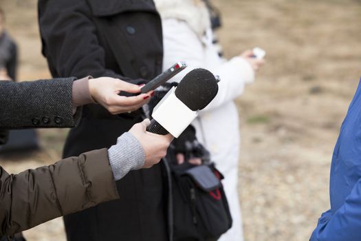 Journalist hand holding a microphone conducting an TV or radio interview