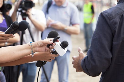 Journalist hand holding a microphone conducting an TV or radio interview