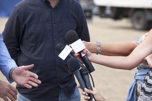 Journalist hand holding a microphone conducting an TV or radio interview