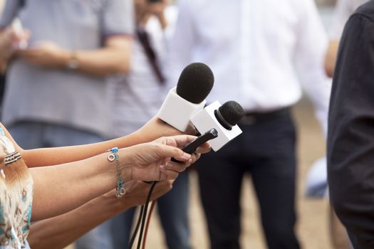 Journalist hand holding a microphone conducting an TV or radio interview