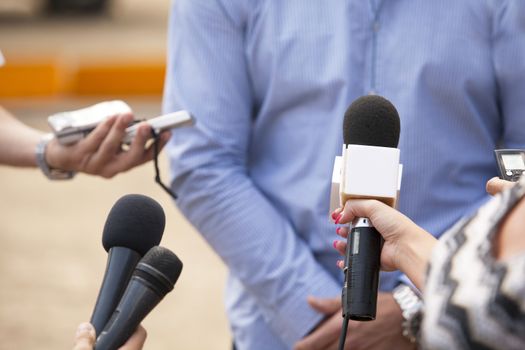 Journalist hand holding a microphone conducting an TV or radio interview