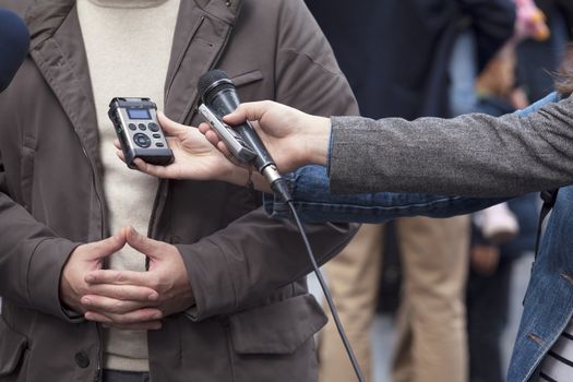 A journalist is making a interview with a microphone