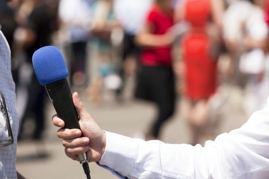 A journalist is making a interview with a microphone