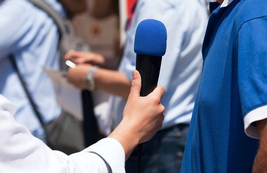 A journalist is making a interview with a microphone