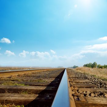 hot sun in blue sky over old railroad