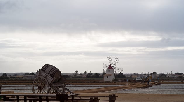 Old windmill on the salines near trapani with lake and bridge