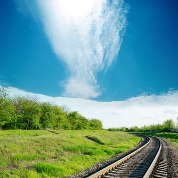 sky with cloud over railroad in green landscape