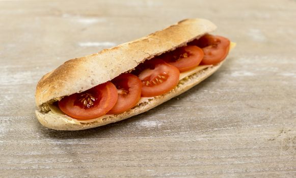 fresh bread from the oven with cheese and tomato on wooden table