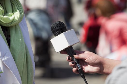 A journalist is making a interview with a microphone