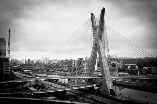 Black and white scenic view of Octavio Frias de Oliveira bridge over Pinheiros river in Sao Paulo, Brazil.