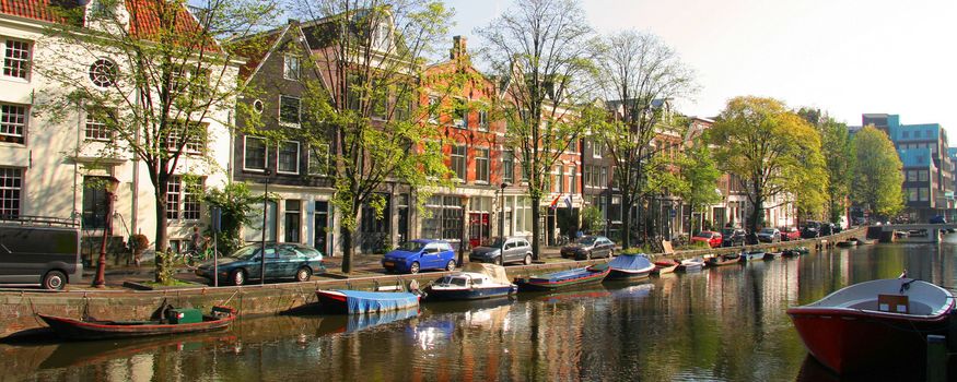 Panoramic view of boats on canal in Amsterdam city, Netherlands.