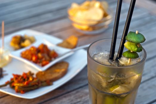 Mojito served in a glass with crushed ice and lime on wooden table