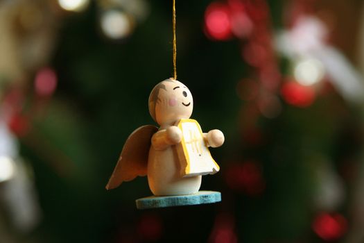 Close-up of a angel shaped Christmas ornament hanging from a golden string