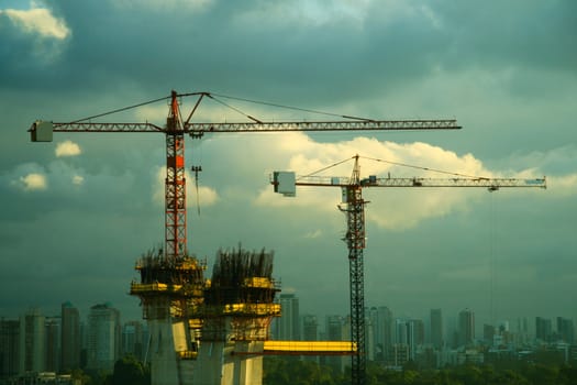 High construction cranes with skyline of Sao Paulo city in background, Brazil.