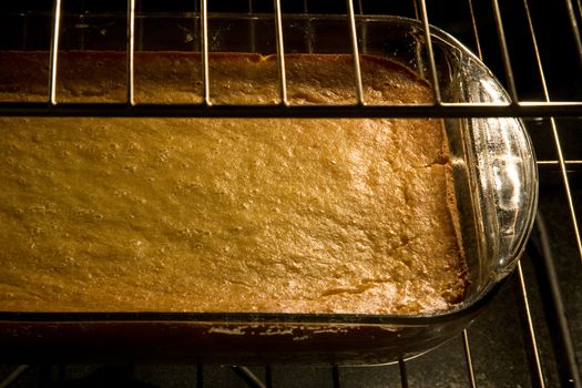 A corn cake in a glass pan in the oven.
