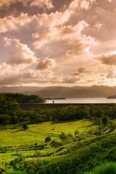 Scenic view of lake and green countryside under cloudscape on island of Costa Rica.