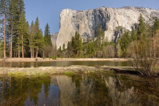 Scenic view of El Capitan rock formations with lake and trees in foreground, Yosemite National Park, California, U.S.A.