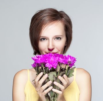 portrait of a teenage girl with flowers in yellow dress - isolated on gray