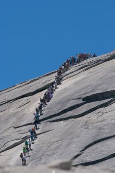 Hikers climbing up the half dome in Yosemite National Park.