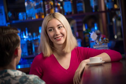 portrait of a nice woman at the bar, talking with a man at the bar date