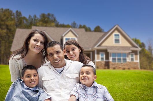 Happy Young Hispanic Family in Front of Their New Home.