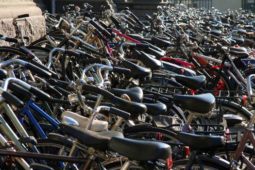 Hundreds of bikes parked on the sidewalk in Amsterdam.