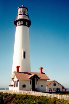 Exterior of lighthouse building with blue sky background.