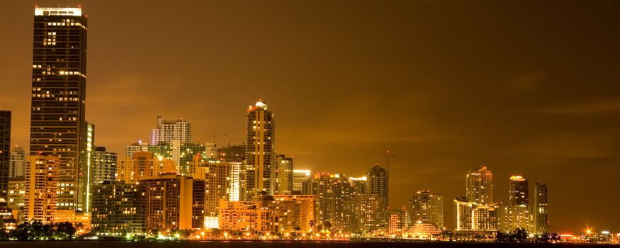 Illuminated commercial buildings at night in downtown Miami, USA.