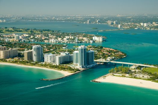 An aerial view of the seashore in Miami with deep green and blue waters.