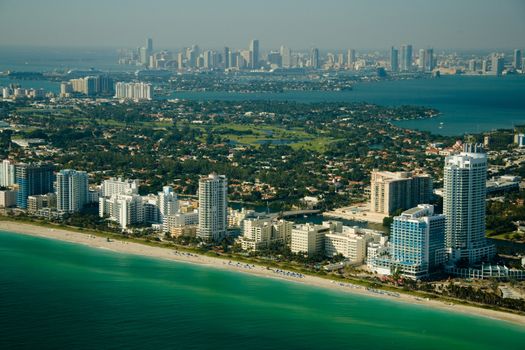 An aerial view of the seashore in Miami with deep green and blue waters.