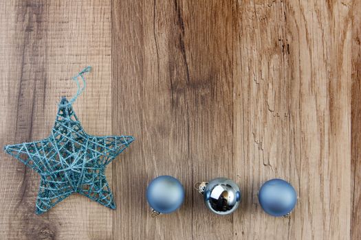 christmas baubles blue and moravian star with wooden background 