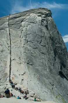 People walking up Half Dome rock formation in Yosemite National Park, California, U.S.A.