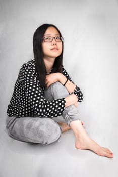 Portrait of girl sitting and holding her knee looking very lonely