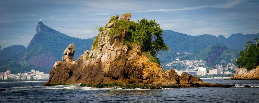 Panoramic view of Rio de Janeiro city coastline with island in foreground, Brazil.