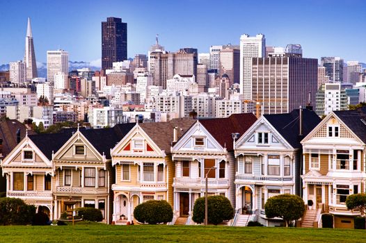 San Francisco's skyline with traditional Victorian houses foreground.