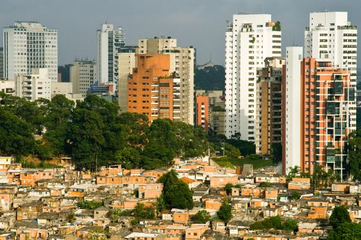 Skyscrapers in Sao Paulo city contrasting with favela shanty town of Morumbi neighborhood in foreground, Brazil.