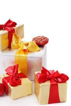 Pile of gift boxes with red and golden ribbon over white