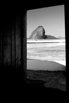 Black and white scenic view of Sugarloaf mountain viewed from doorway of Santa Cruz fortress, Niteroi, Brazil.