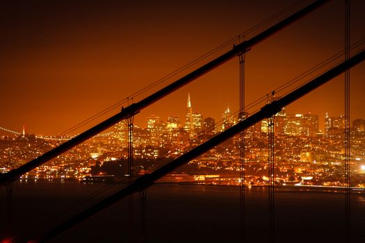 Transamerica Pyramid seen at night through the cables of the Golden Gate Bridge, San Francisco Bay, San Francisco, California, USA